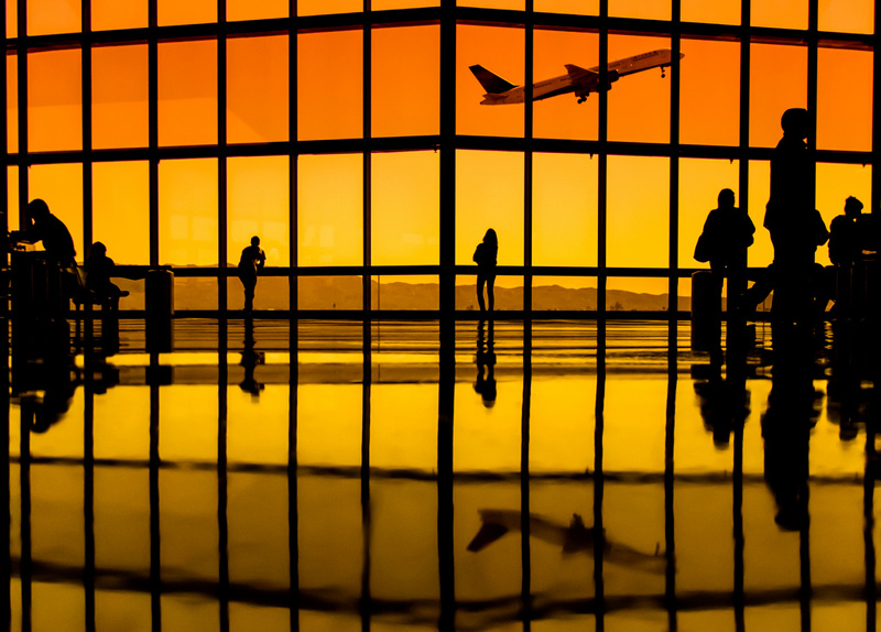 watching-planes-takeoff-through-terminal-windows-yellow-orange-tint.jpg